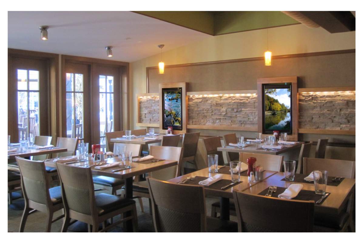 Interior design photo of restaurant dining room with natural color Dal-Tile stone and painted walls, weathered cedar table tops and dining room chairs by  and chair finishes, pale olive upholstery, painted accent walls and digital display artwork featuring collection of outdoor scenery of Great Falls, Virginia historical park site, 